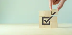 Placing wooden cube with checkmark icon.